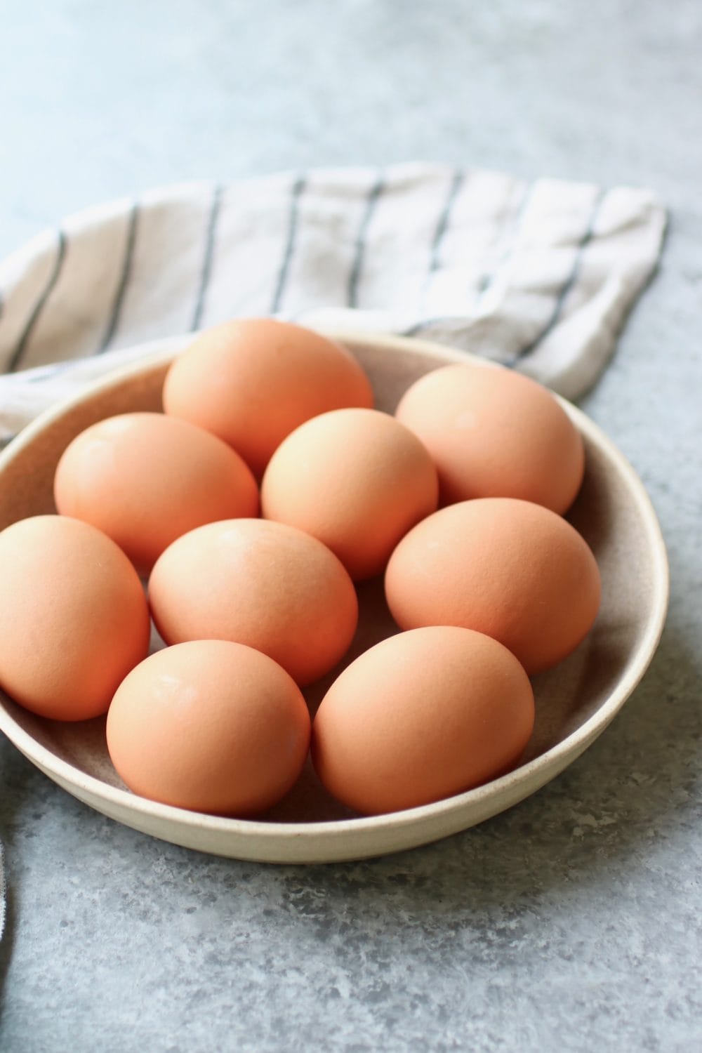 A low profile bowl filled with brown eggs ready to be made into hard-boiled eggs 