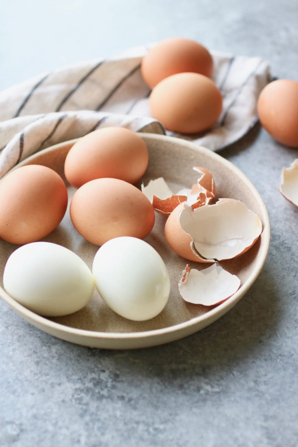 Freshly hard-boiled eggs with easy-peel shells in a shallow bowl 