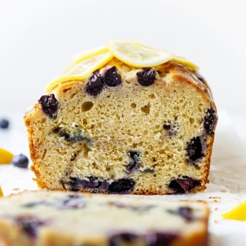 Freshly cut lemon blueberry loaf topped with thin lemon slices.