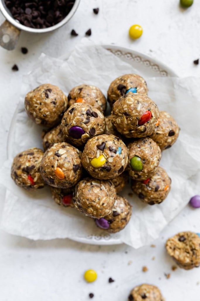 Monster Cookie Peanut Butter Protein Balls perfectly rolled into balls with colorful candy-coated chocolate pieces in each ball, all stacked up in a large pile.