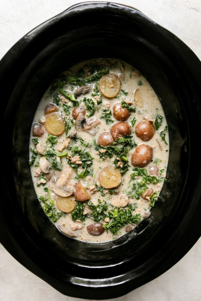 Overhead view zuppa toscana soup in black crockpot
