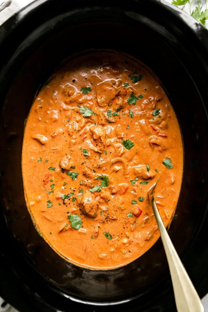 Overhead view of a crockpot filled with Butter Chicken ingredients. 